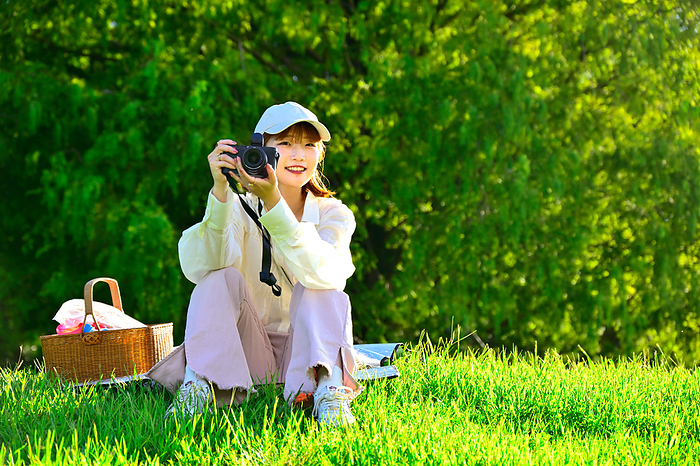 Young woman picnicking on a green hill