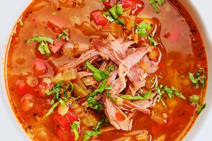 Close up view of thick, spicy and sour soup with beef on dark wooden table