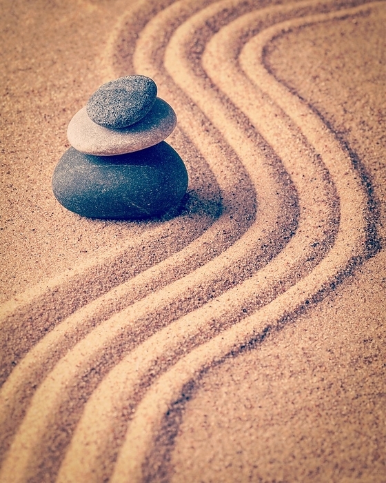 Vintage retro effect filtered hipster style image of Japanese Zen stone garden, relaxation, meditation, simplicity and balance concept, pebbles and raked sand tranquil calm scene