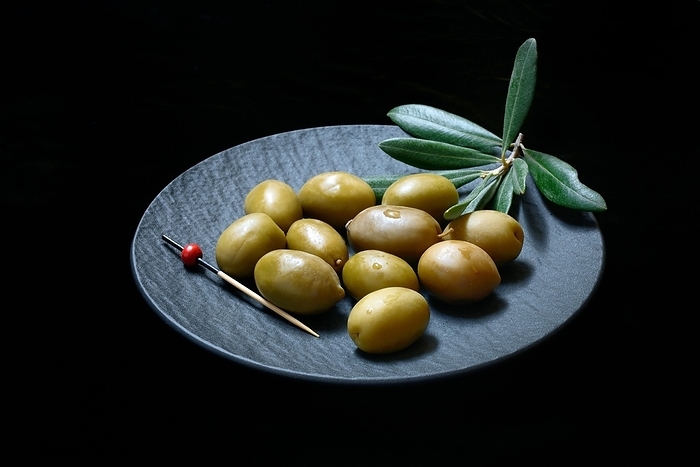 Greek olives from Chalkidiki on plate with toothpick, Germany, Europe
