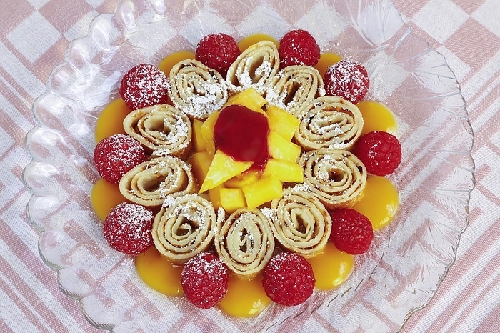 Swabian cuisine, sweet Flädle, pancakes with raspberries and mango, icing sugar, dessert, dessert on glass plate, Germany, Europe