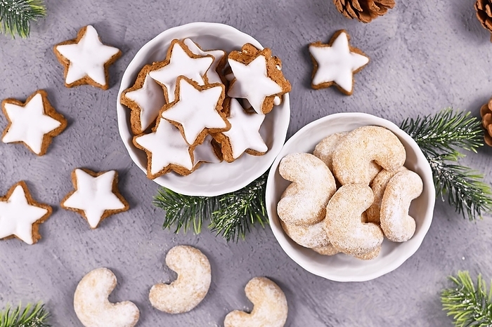 Bowls with traditional German and Austrian Christmas cookies, one filled with cinnamon star cookies, the other with crescent shaped almond cookies