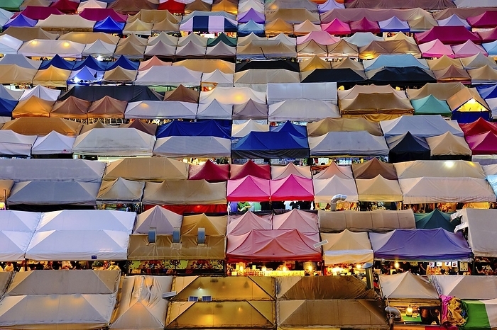 Colorful market tents at sunset. Fairs and marketplaces, small businesses, food stalls, shopping and dining outdoors, Asian markets, local traditions, tourist traps or attractions. Ratchada Rot Fai train night market, Bangkok, Thailand, Asia