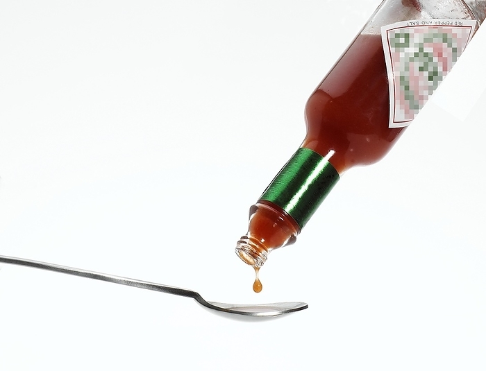 Tea Spoon with Tabasco, Hot Pepper Sauce, Bottle against White Background