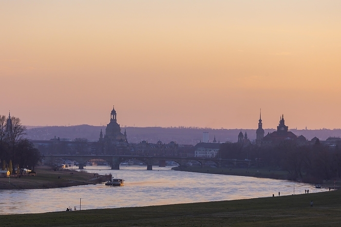Evening sky over the old town of Dresden with the Church of Our Lady, the castle tower, the Hofkirche and the State Chancellery. In the foreground the Ferry Garden and the Elbe ferry