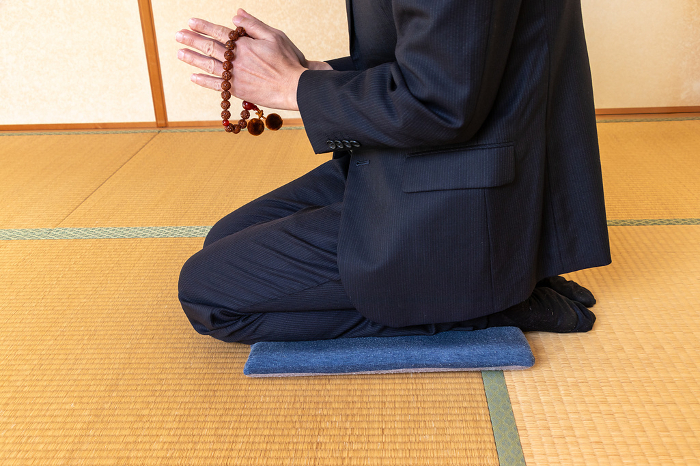 A man holding a prayer bead in his hand