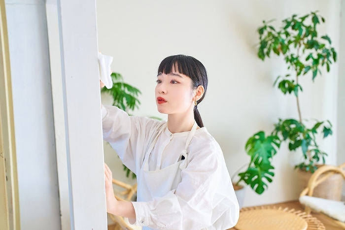 Young Japanese woman wiping down a room (People)