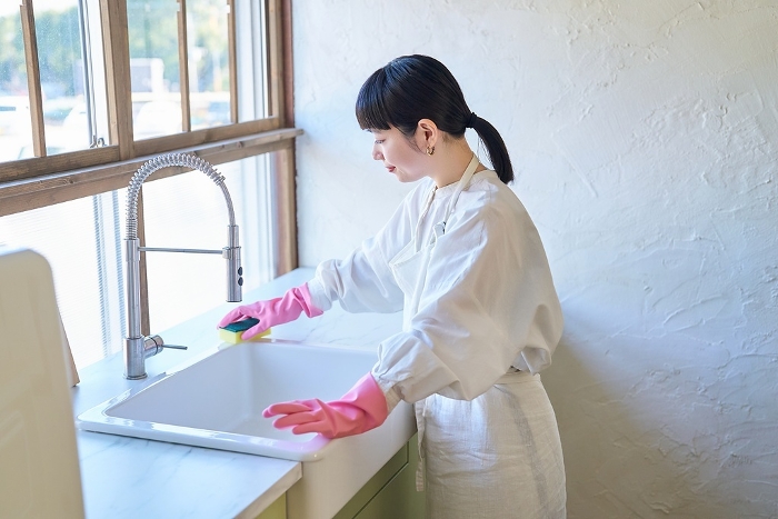 Young Japanese woman cleaning the kitchen sink (People)
