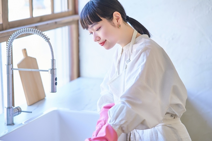 Young Japanese woman cleaning the kitchen sink (People)