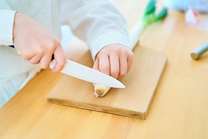 Young woman cutting food with a knife