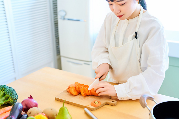 Young woman cutting food with a knife