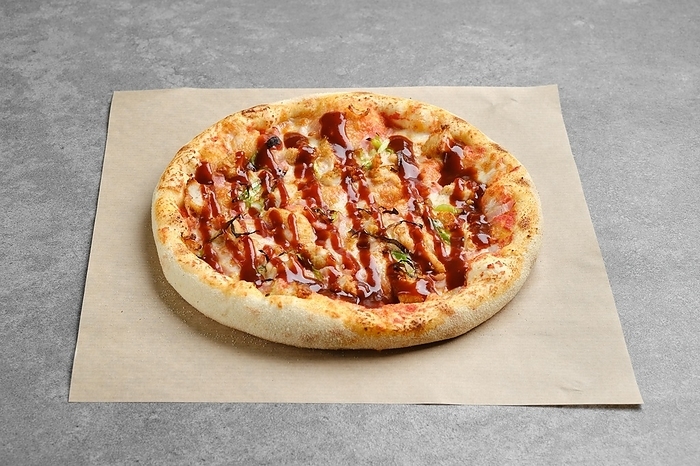 Barbecue pizza with bacon and spring onion on parchment paper, by Aleksei Isachenko