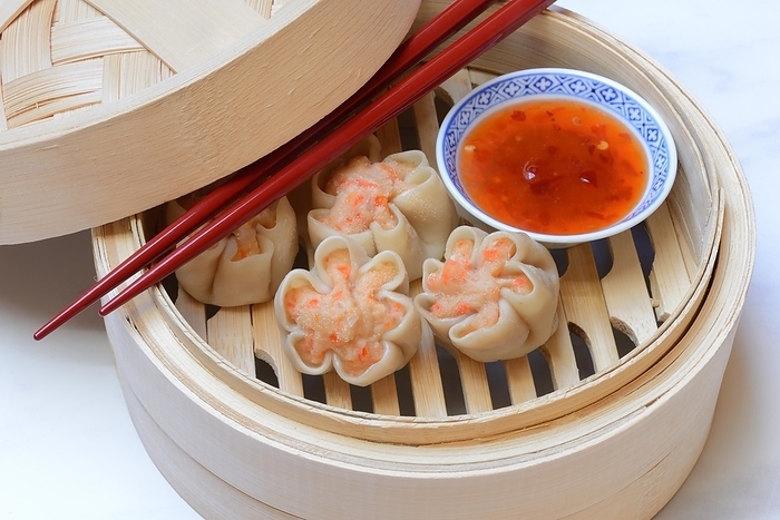 Dim Sum, filled dumplings with chopsticks and chilli sauce in steam baskets, Germany, Europe, by Jürgen Pfeiffer