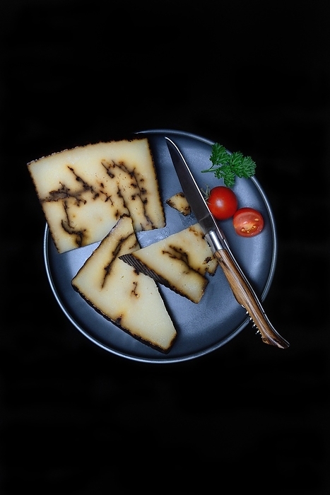 Sheep cheese with black garlic on plate with knife, Spain, Europe, by Jürgen Pfeiffer