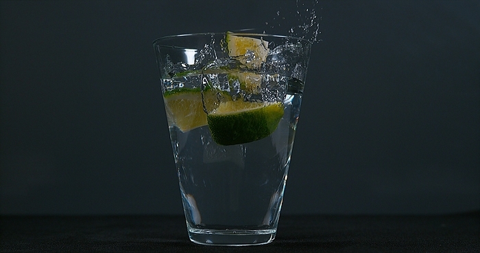 Green Citrus (citrus aurantifolia), falling into a Glass of Water, by Lacz Gerard