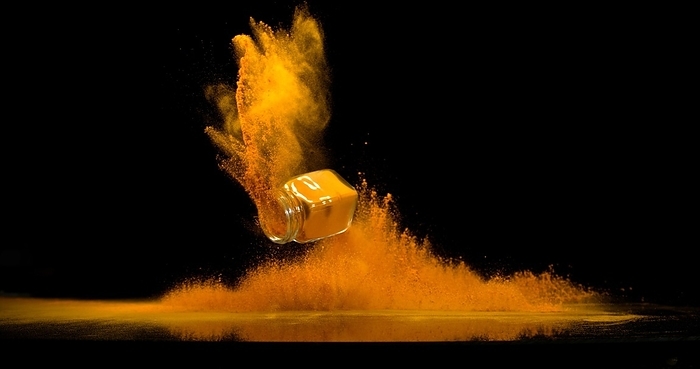 Turmeric (curcuma longa), Powder into a small jar falling against Black Background, Indian Spice, by Lacz Gerard