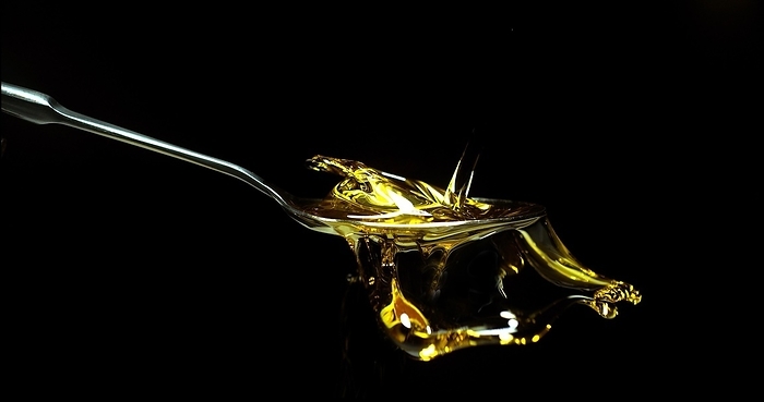 Olive Oil, Falling in a Spoon against Black Background, by Lacz Gerard