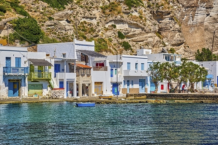 Close view of colorful village of Klima with Greek whitewashed houses on sunny day, Milos island, Cyclades, Greece. Traditional fishermen village, bright painted and weathered doors and doorways, high hill, azure sea, summer sunshine, vacations, by Natallia Pershaj