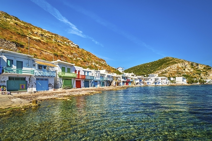 Colorful village of Klima with Greek whitewashed houses on sunny day, Milos island, Cyclades, Greece. Traditional fishermen village, bright painted and weathered doors and doorways, high hill, great blue sky, azure sea, summer sunshine, vacations, by Natallia Pershaj