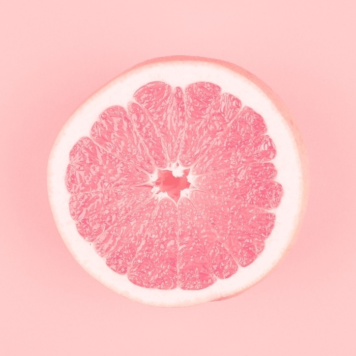 Pink halved fresh juicy grapefruit pink background, by Oleksandr Latkun