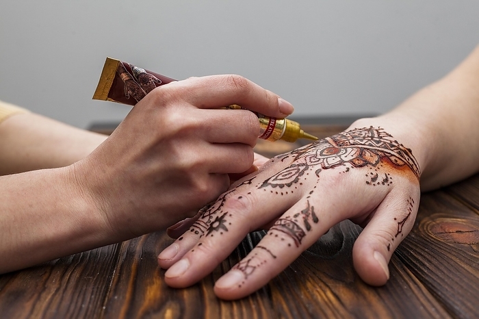 Artist making mehndi womans hand table, by Oleksandr Latkun