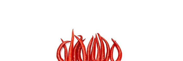 Red chillies arranged against a white background. The image crop has enough free areas to use the image as a template, by fotoping