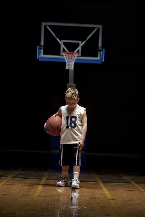 Young Boy Standing On Basketball Court Looking Solemn, by Ron Nickel / Design Pics