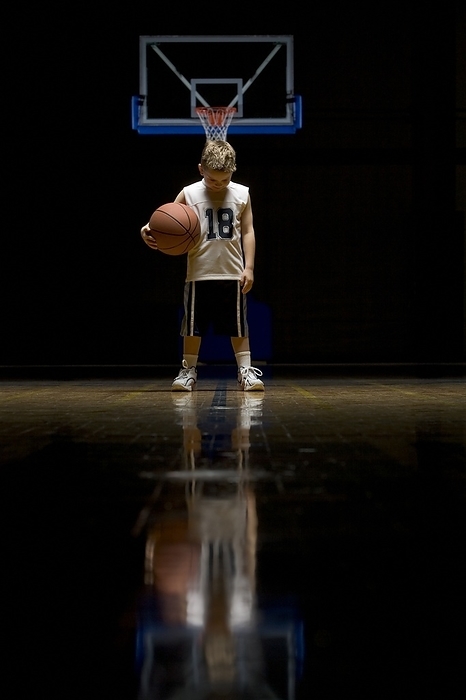 Young Boy Standing On Basketball Court Looking Solemn, by Ron Nickel / Design Pics