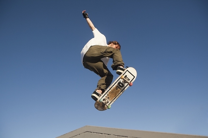 Low Angle View Of Young Male Skateboarder, by Marcos Welsh / Design Pics