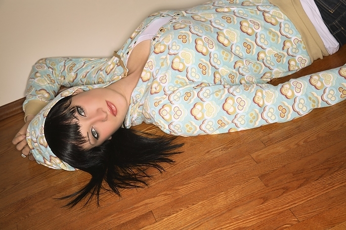 Young Woman Lying On The Floor In Hoodie, by Leah Hammond / Design Pics