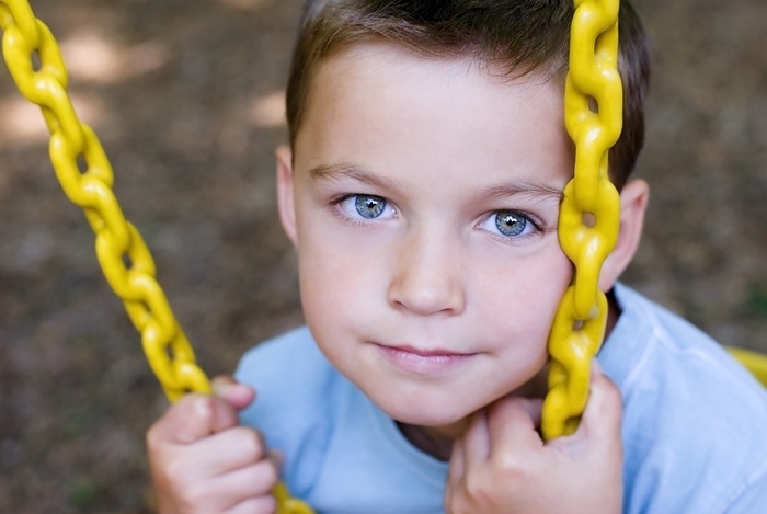Close-Up Of Boy Playing On Swing Set, by Craig Craver / Design Pics