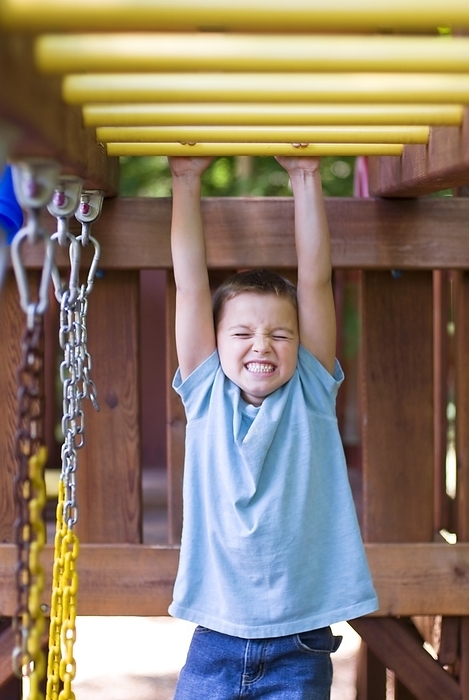 Young Boy Playing On Jungle Gym Swing Set, by Craig Craver / Design Pics