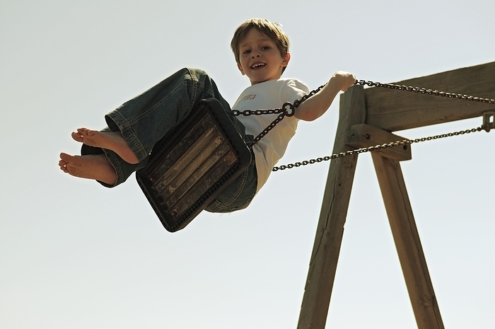 Boy Playing On Swings, by Ben Welsh / Design Pics
