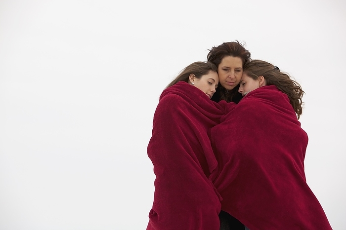 Mother And Daughters Huddle Together Outdoors Under Blanket, by Ron Nickel / Design Pics