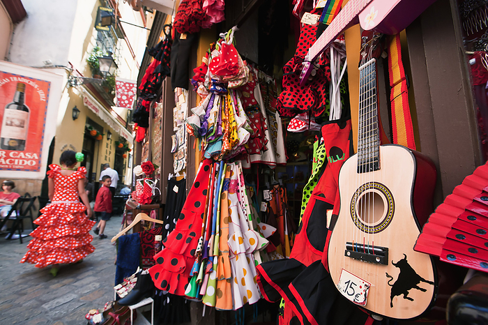 Seville, Spain Girl In Traditional Seville Dress Passing Shop Selling Souvenirs In Old Town  Santa Cruz, Seville, Andalucia, Spain, by Paul Quayle   Design Pics