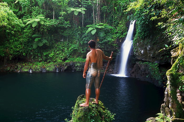 Samoan With Full Body Tattoo Stands In Front Of Waterfall; Savaii Island, Samoa, by David Kirkland / Design Pics