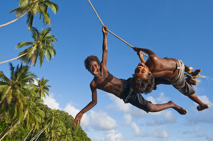 Solomon Island Kids Swinging From A Rope; Gizo, Western Province, Solomon Islands, by David Kirkland / Design Pics