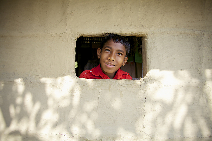 Bangladesh A Boy Sticks His Head Out A Small Window In A Wall  Sunamganj, Bangladesh, by Ian Taylor   Design Pics