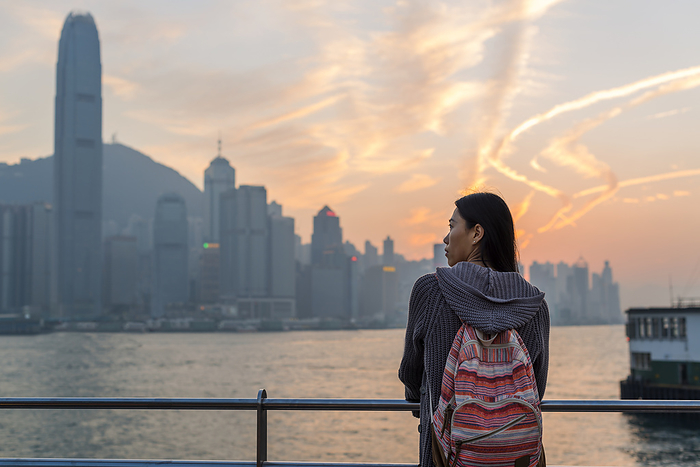 China Hong Kong A Young Woman At The Waterfront With A View Of The Skyline At Sunset, Kowloon  Hong Kong, China, by Luis Martinez   Design Pics