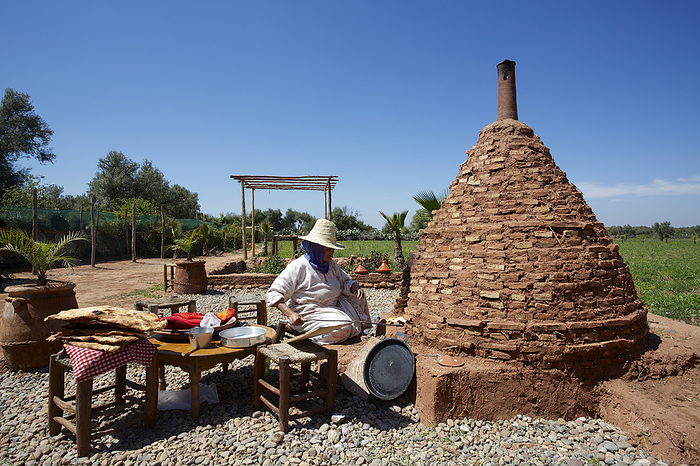 Morocco Woman Baking Flat Bread In Traditional Oven In Rural Atlas Mountain Landscape, Morocco, by Chris Caldicott   Design Pics