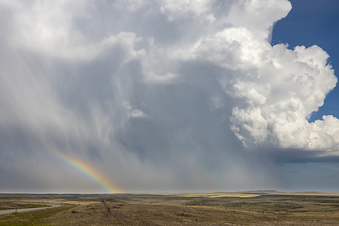 Huge thunderhead dumping rain and hail on the prairie of Southeast Wyoming providing a wonderful rainbow for those on this side of the storm; Chugwater, Wyoming, United States of America, by Doug Ogden / Design Pics