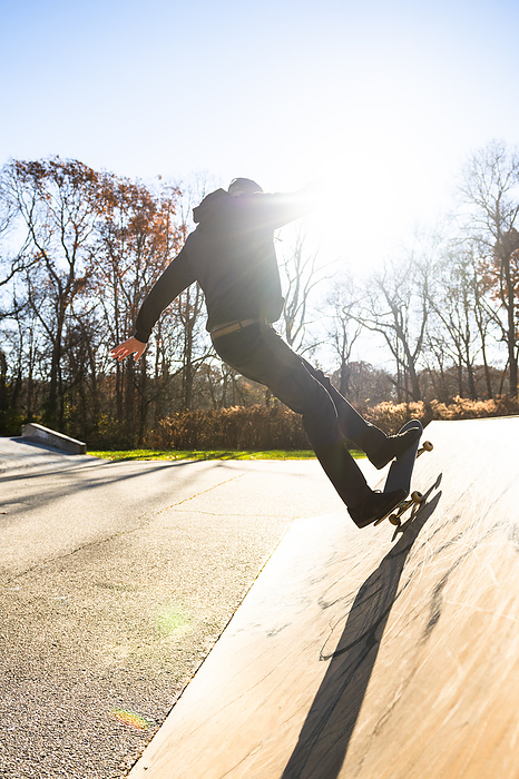 Cate Brown    Commercial Lifestyle Photography in Rhode Island Solo Man skateboarding a skatepark ramp in autumn with lens flare, by Cavan Images   Cate Brown