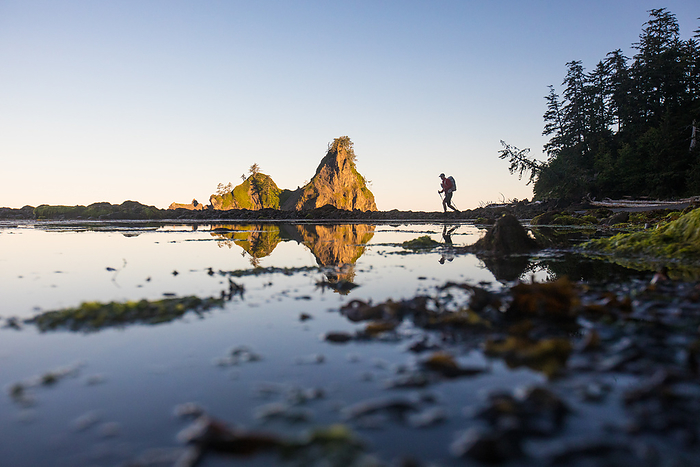 Reflection of distant backpacker hiking Pacific Northwest Trail, by Cavan Images / Christopher Kimmel / Alpine Edge Photography