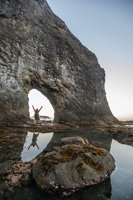 Reflection of Backpacker with arms raised at Hole-In-The-Wall, by Cavan Images / Christopher Kimmel / Alpine Edge Photography
