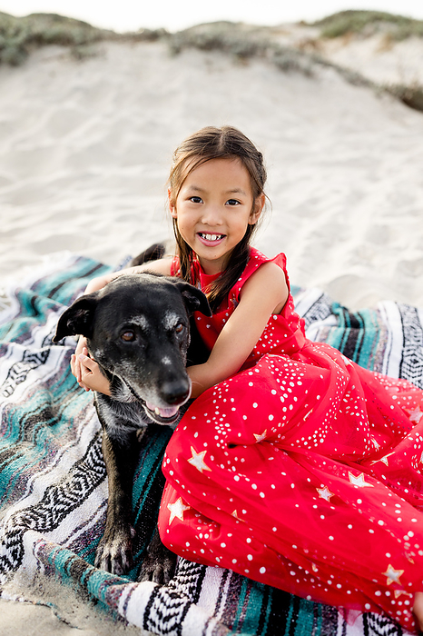 Asian Girl Posing with Dog on Beach in San Diego, by Cavan Images / Jill Denny Soto