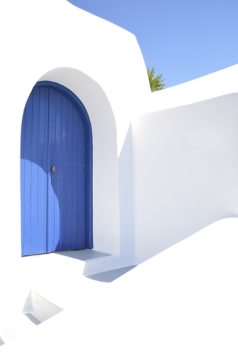 Picturesque door with blue sky on the Greek island of Santorini, by Cavan Images / Hernán Pagano