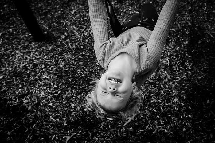 Happy young child playing on swings, by Cavan Images / Krista Taylor