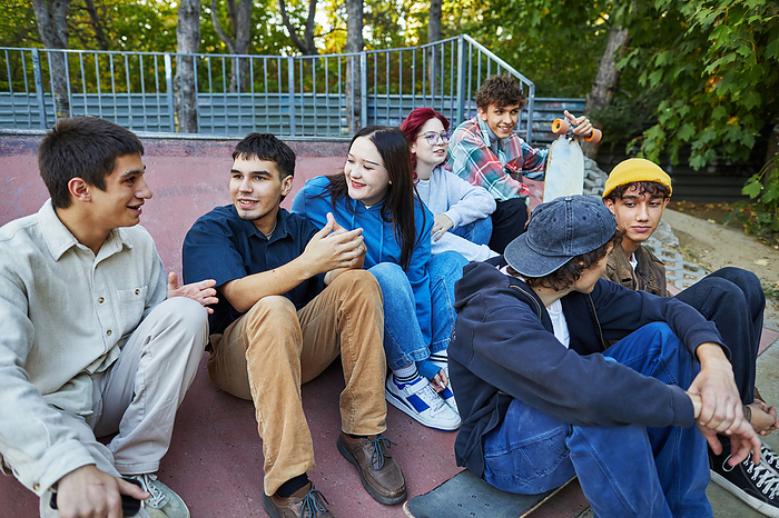 group of friends chatting in the skate park, by Cavan Images / Elena Perevalova