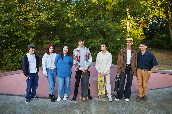 a group of young people with skateboards stands in a skate park, by Cavan Images / Elena Perevalova