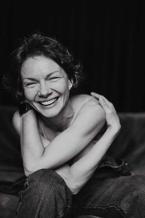 Smiling woman with short hair, black and white emotional portrait., by Cavan Images / Yuliya Kirayonak